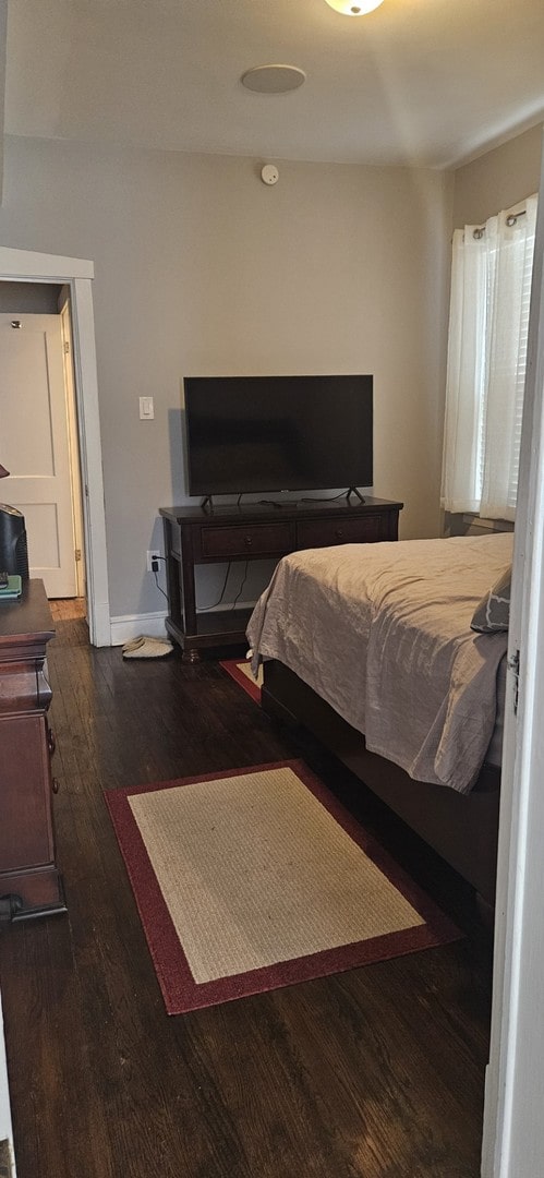 bedroom with dark hardwood / wood-style flooring