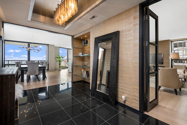 interior space with an inviting chandelier and a wall of windows