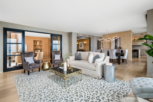 living room with a notable chandelier and light hardwood / wood-style flooring