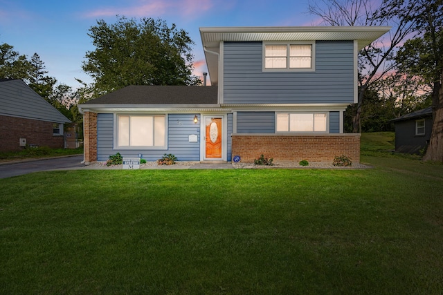 view of front facade with a front lawn and brick siding