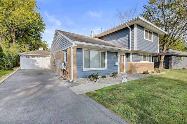 view of front of property featuring a garage, a front yard, and an outbuilding