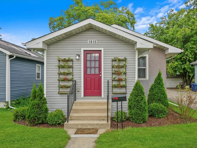 bungalow-style home with a front yard