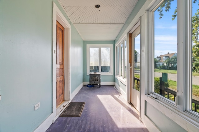 unfurnished sunroom featuring a wood stove