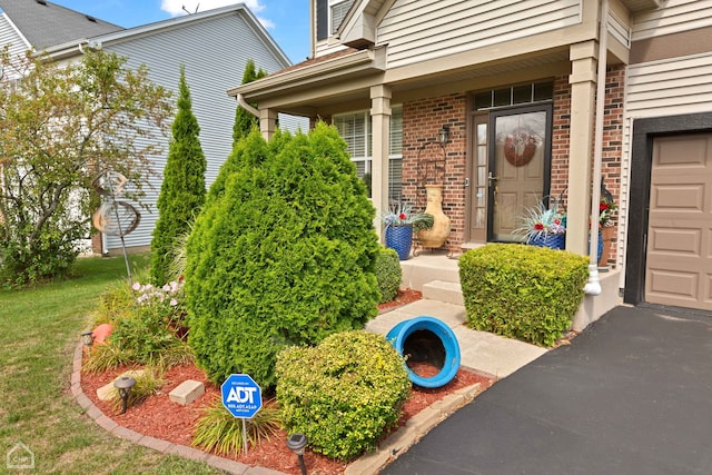 view of exterior entry featuring a porch and a garage