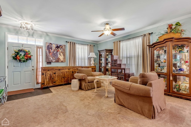 carpeted living room with ceiling fan and ornamental molding