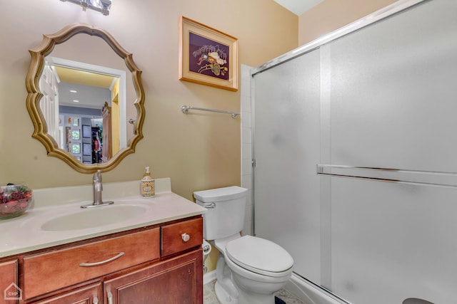 bathroom featuring tile patterned floors, walk in shower, vanity, and toilet