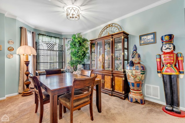 dining room featuring ornamental molding and light colored carpet