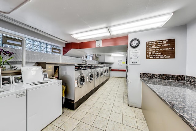 community laundry room with light tile patterned flooring and separate washer and dryer
