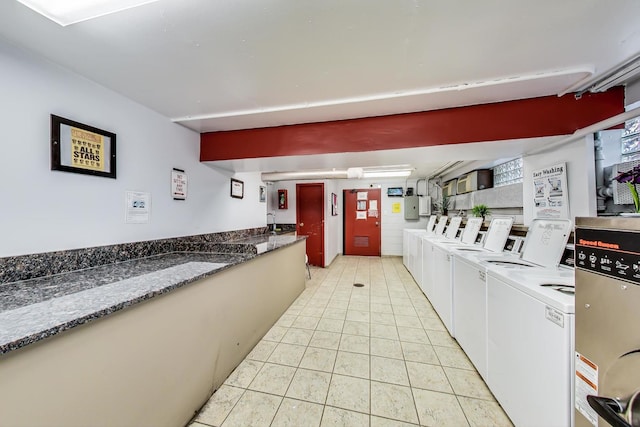 kitchen featuring light tile patterned flooring, white cabinetry, and independent washer and dryer