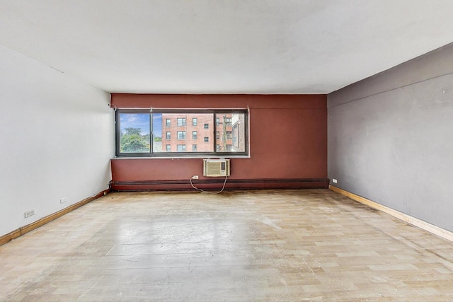 empty room with a wall unit AC, baseboards, a baseboard heating unit, and wood finished floors