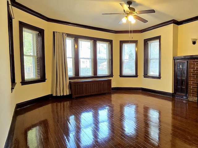 spare room featuring hardwood / wood-style floors, crown molding, a healthy amount of sunlight, and radiator heating unit