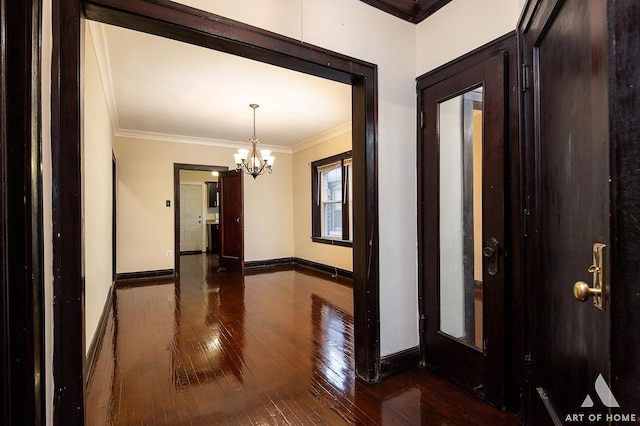 interior space with ornamental molding, dark wood-type flooring, and an inviting chandelier