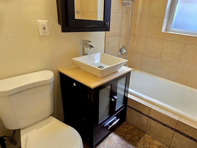 full bathroom with tiled shower / bath, vanity, and toilet