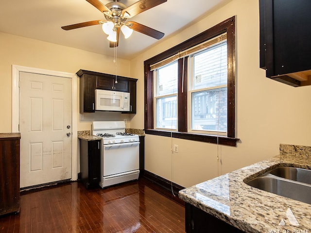 kitchen with ceiling fan, light stone countertops, dark hardwood / wood-style floors, and white appliances