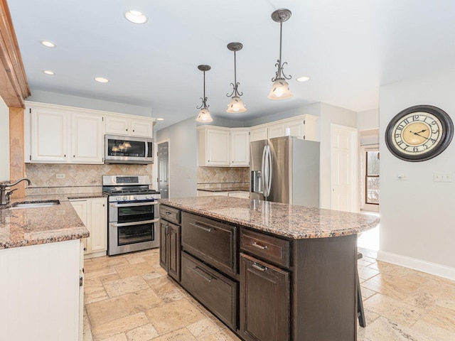 kitchen with sink, tasteful backsplash, dark brown cabinets, a kitchen island, and stainless steel appliances