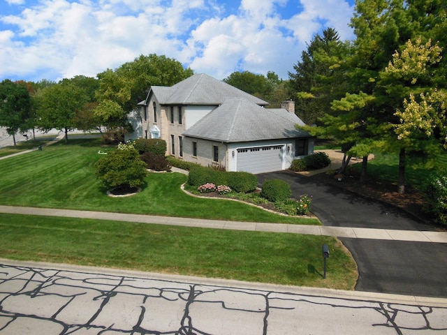 view of front of house with a garage and a front lawn