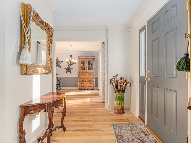 entrance foyer with a notable chandelier, hardwood / wood-style flooring, and ornamental molding