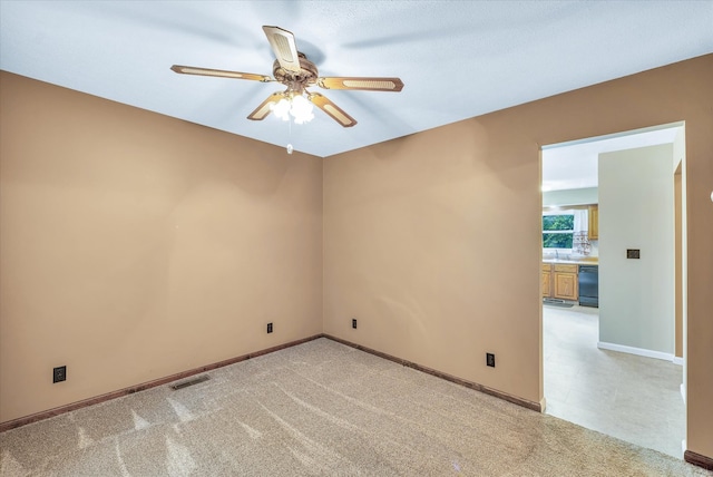 unfurnished room with ceiling fan and light colored carpet