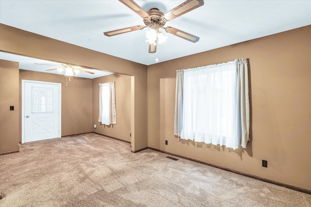 carpeted spare room with ceiling fan