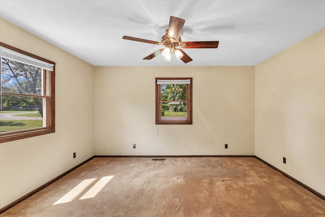 unfurnished room with ceiling fan and light carpet