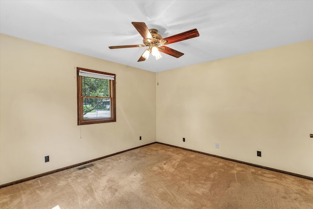 spare room with ceiling fan and light carpet