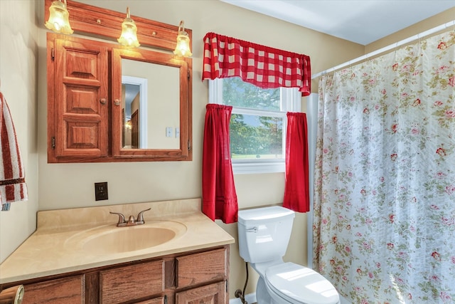 bathroom with toilet, vanity, and walk in shower