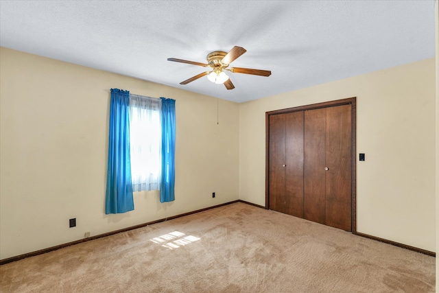 unfurnished bedroom with ceiling fan, light carpet, and a closet