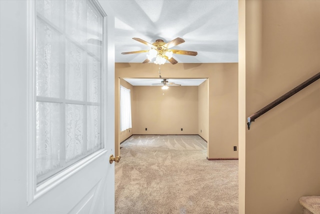 spare room with ceiling fan and light carpet