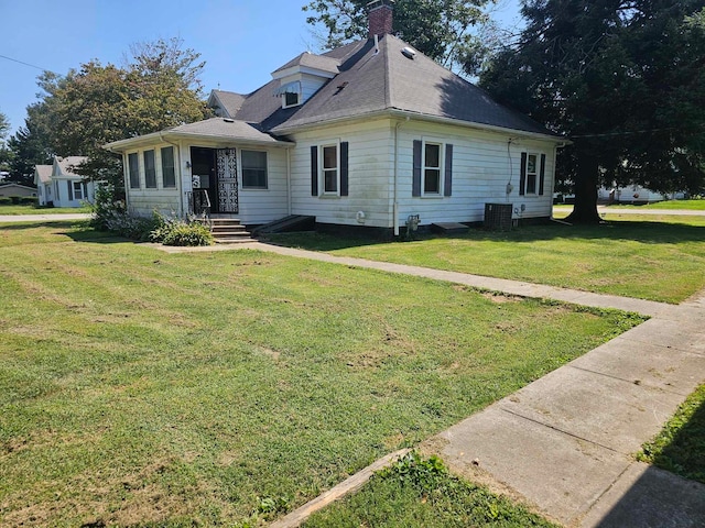 view of front of property with central air condition unit and a front lawn