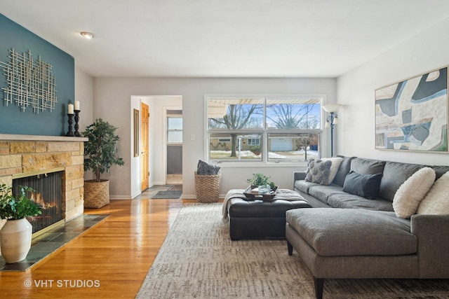 living room featuring hardwood / wood-style floors and a stone fireplace