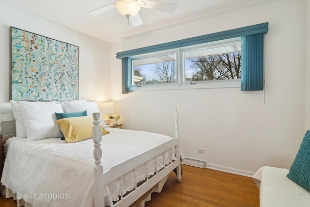 bedroom with ceiling fan, baseboard heating, and hardwood / wood-style floors