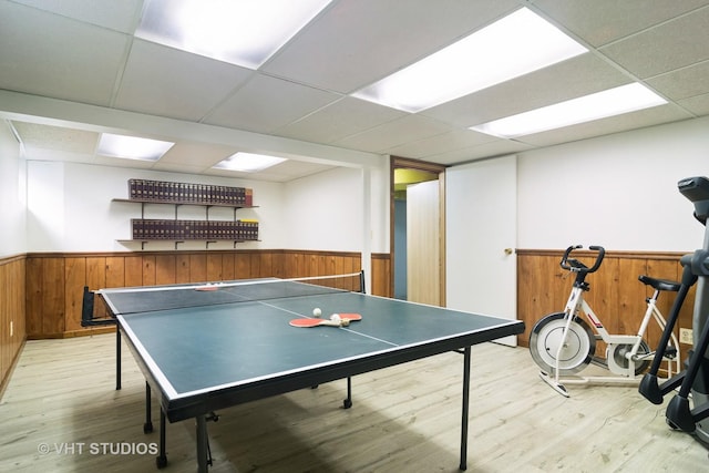 recreation room with a paneled ceiling and light hardwood / wood-style flooring