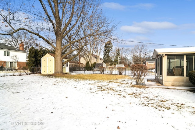 yard layered in snow with a shed