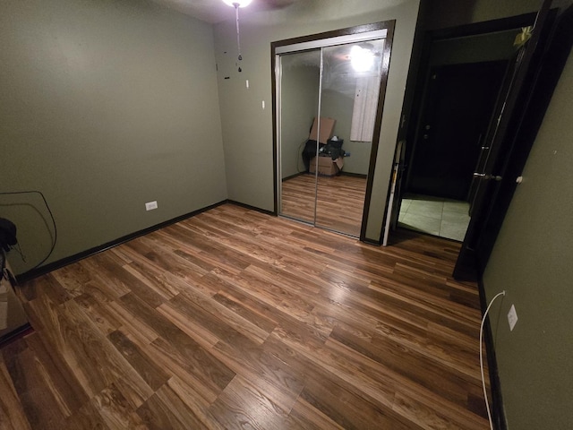 unfurnished bedroom with dark hardwood / wood-style floors and a closet