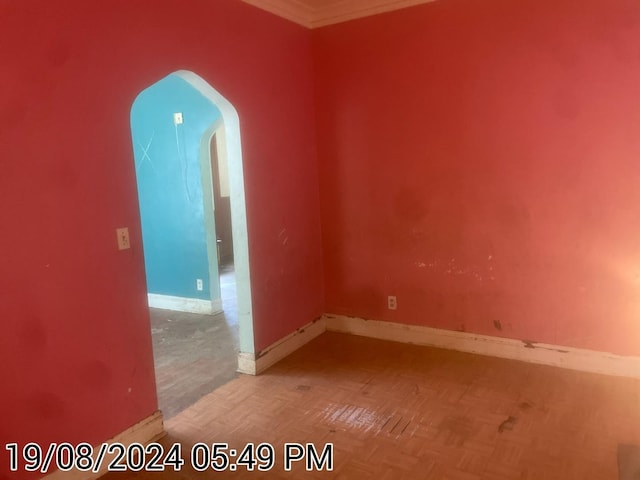 empty room featuring baseboards and arched walkways