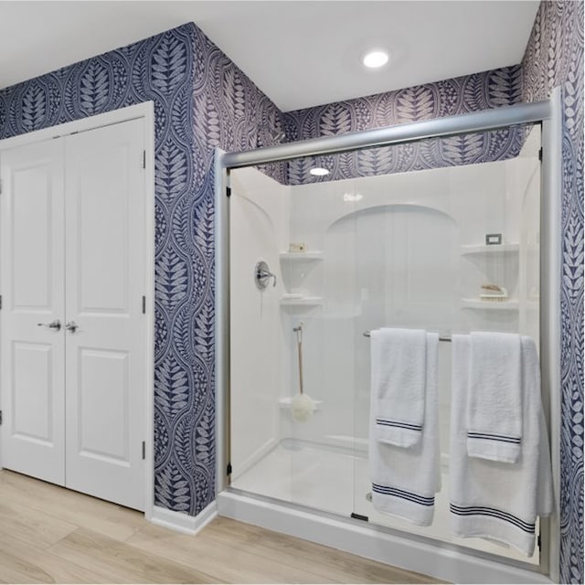 bathroom with wood-type flooring and an enclosed shower