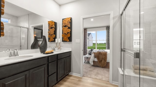 bathroom with hardwood / wood-style flooring, vanity, and walk in shower