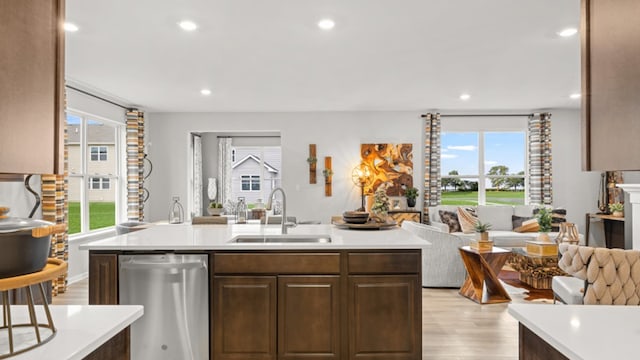 kitchen featuring light wood-type flooring, sink, plenty of natural light, and dishwasher