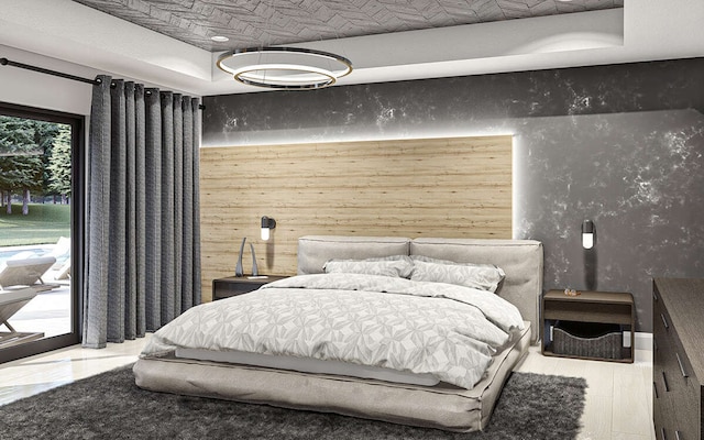 bedroom with a raised ceiling and access to exterior