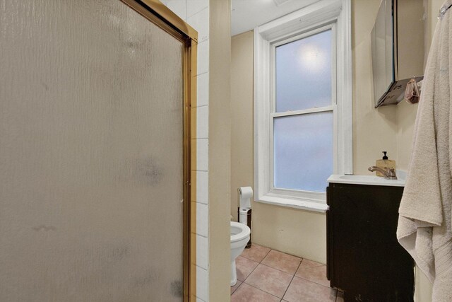 bathroom featuring toilet, a shower stall, vanity, and tile patterned floors