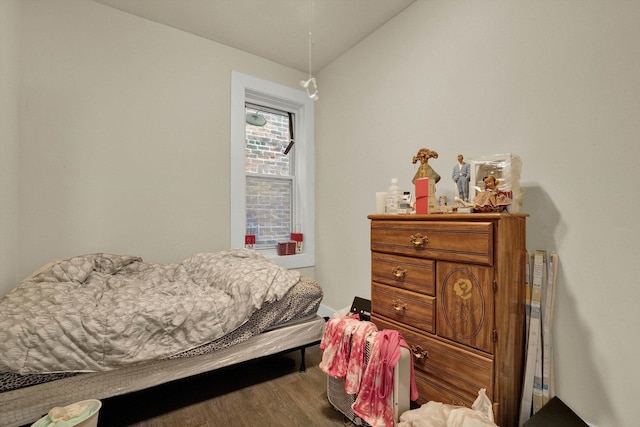 bedroom with vaulted ceiling and wood finished floors