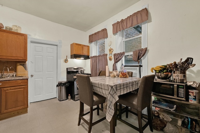 tiled dining room featuring cooling unit and sink