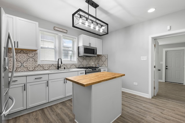 kitchen featuring dark wood-type flooring, stainless steel appliances, decorative backsplash, and wooden counters