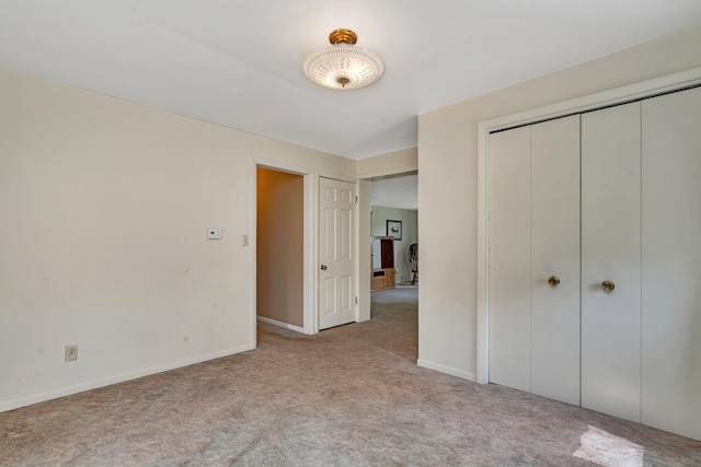 unfurnished bedroom with a closet, carpet flooring, and baseboards