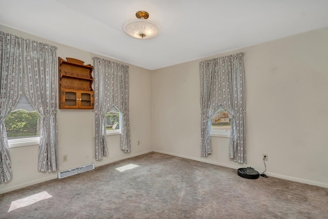 carpeted empty room featuring visible vents and baseboards