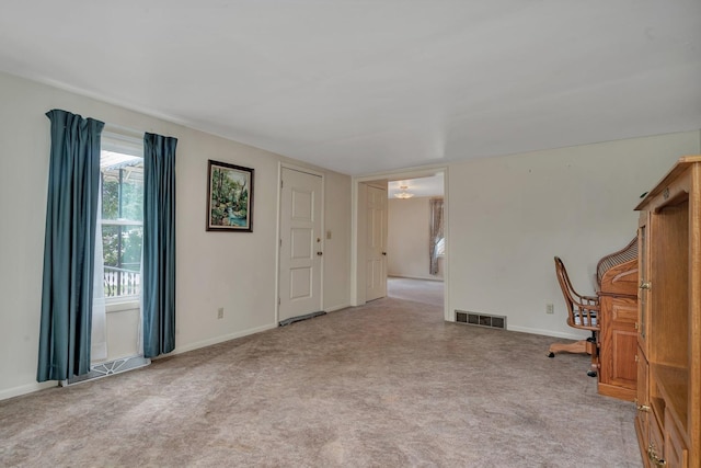 unfurnished office with carpet, visible vents, and baseboards