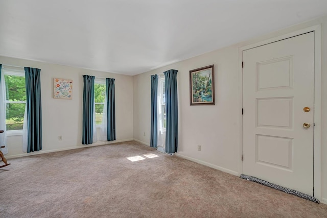 carpeted empty room featuring baseboards