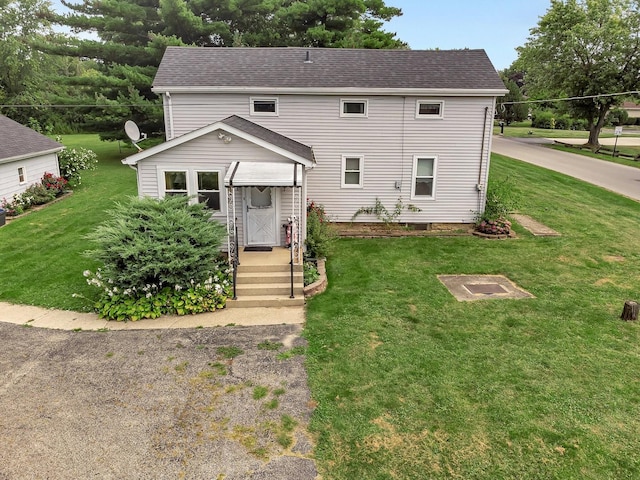 view of front of house with a shingled roof and a front lawn