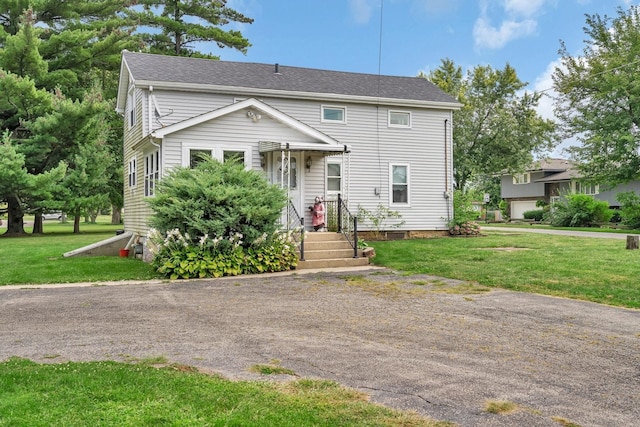 view of front of house with a shingled roof and a front lawn