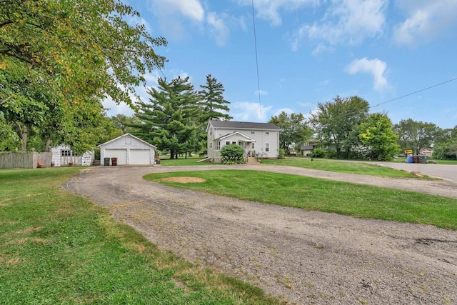 view of front of property with a garage, fence, a front lawn, and an outbuilding